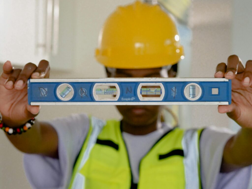 Close-up of construction worker holding a spirit level indoors.